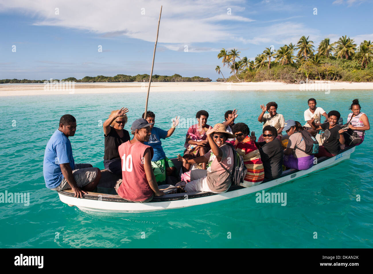 Longboat (fiibreglass) piena di paesani lascia l'ancoraggio orientale, Fulaga, southern Laus, Fiji. Foto Stock