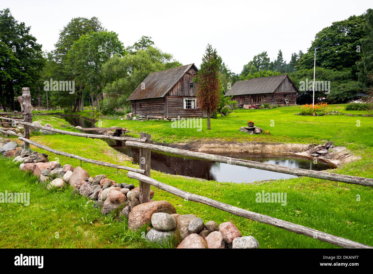 Agriturismo con ampio e verde giardino con laghetto e legname e ciottoli cantiere di pietra Foto Stock