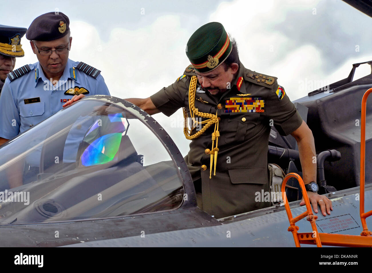 Il sultano del Brunei Haji Hassanal Bolkiahsutan si arrampica nel cockpit di un Singapore Air Force F-15E Strike Eagle durante la quarta Biennale Brunei Darussalam International Defence Exhibition sul flightline Rimba a base di aria Dicembre 3, 2013 Brunei. Foto Stock