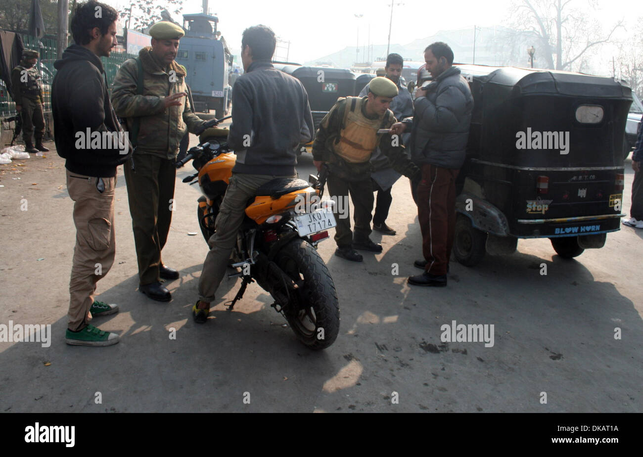 Srinagar, Indiano Kashmir amministrato del04 dicembre 2013 poliziotti indiano frisks durante un high security alert in srinagar ,la capitale estiva di indiano Kashmir amministrato. Un elevato livello di sicurezza è stata intensificata in srinagar dopo il funzionario di polizia è stato ucciso e due suoi colleghi feriti mentre erano di pattuglia un mercato in chadoora città nel distretto di budgam 25km (16 miglia) da srinagar. (Sofi Suhail/ Alamy Live News) Foto Stock