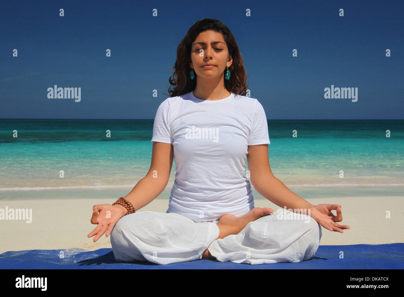 Giovane donna fare yoga lotus pongono, Paradise Island, a Nassau, Bahamas Foto Stock