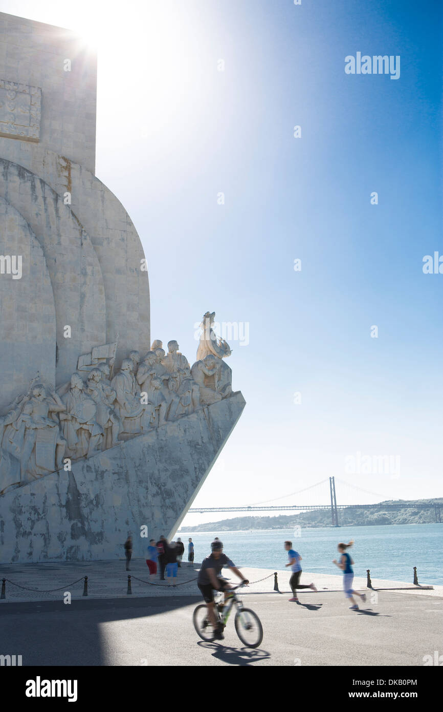 Cicli di uomo passato il Monumento alle Scoperte, Belem, Lisbona, Portogallo Foto Stock