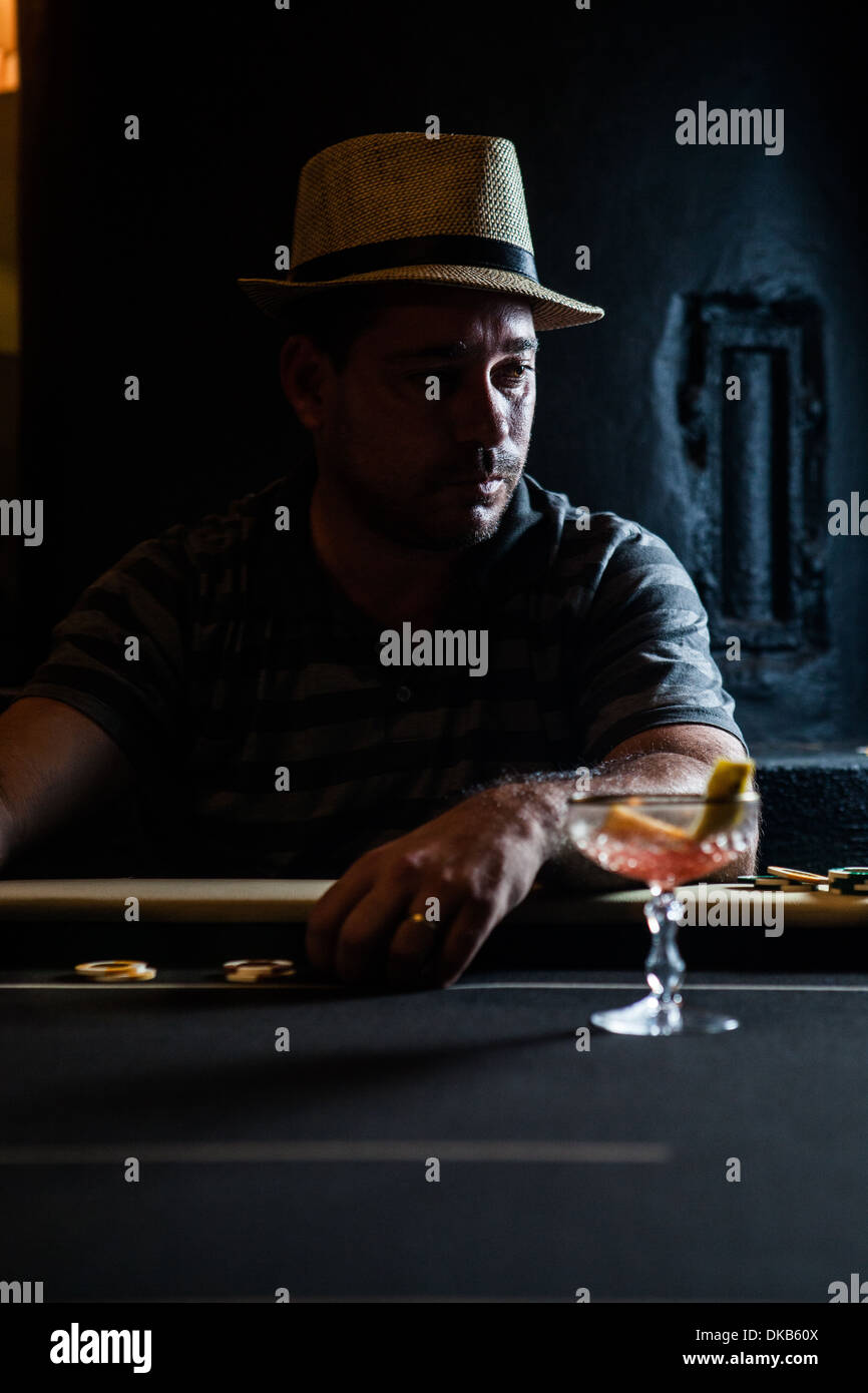 Metà uomo adulto seduto a tavola con fiche e cocktail Foto Stock