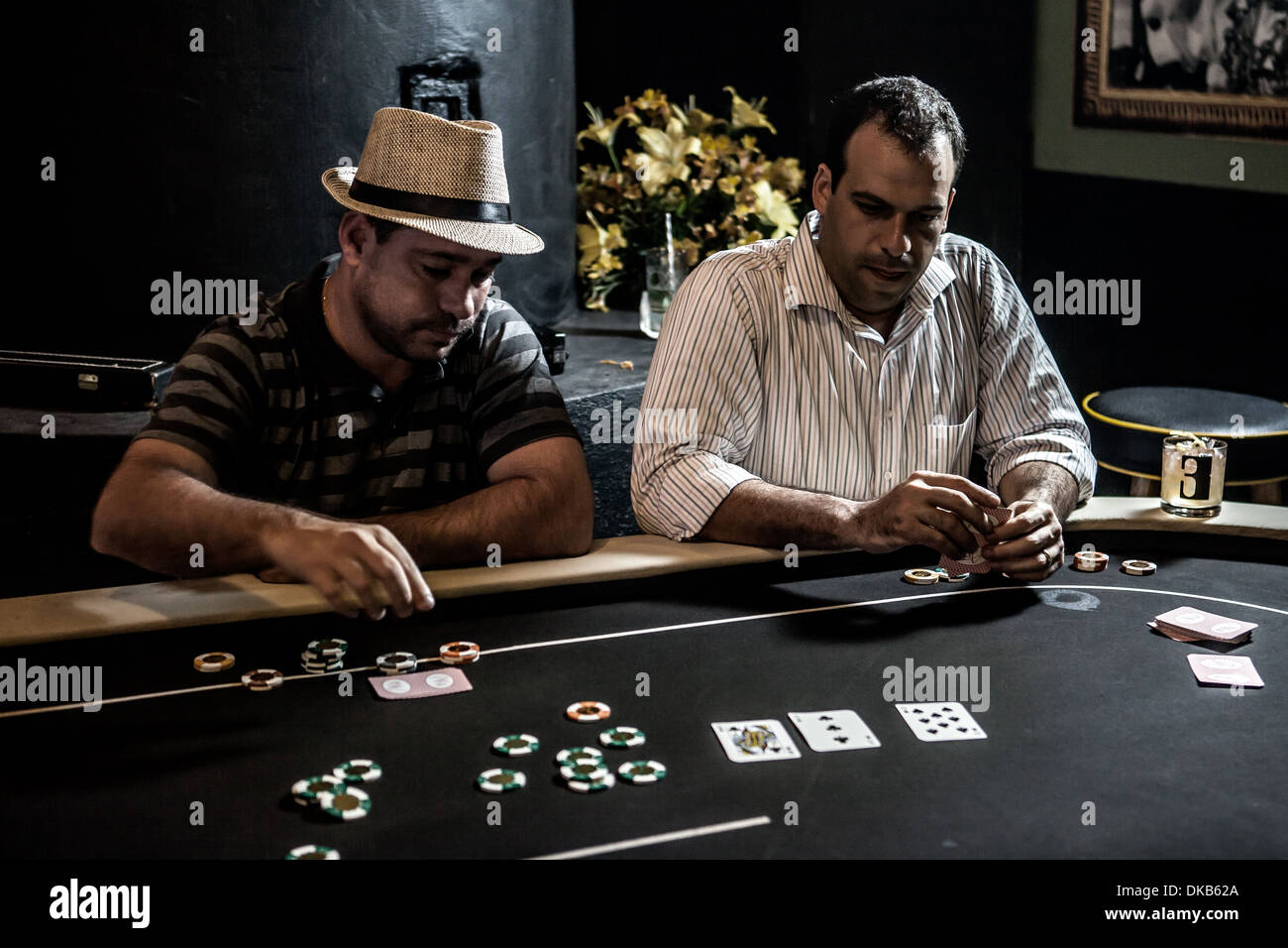 Metà uomini adulti giocando a poker e bere cocktail Foto Stock