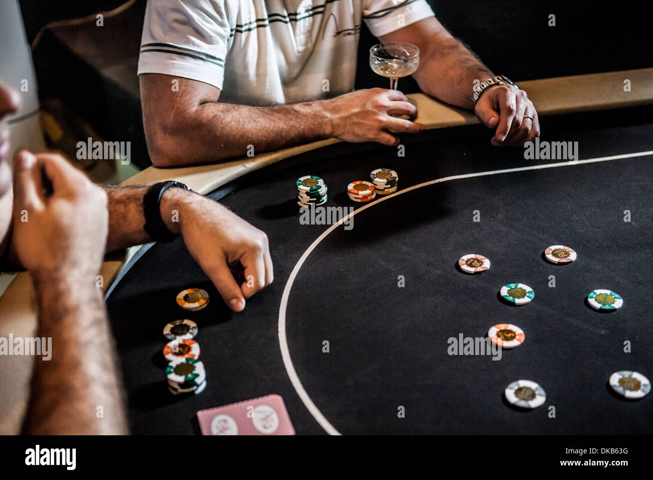 Metà uomini adulti giocando a poker e bere cocktail Foto Stock