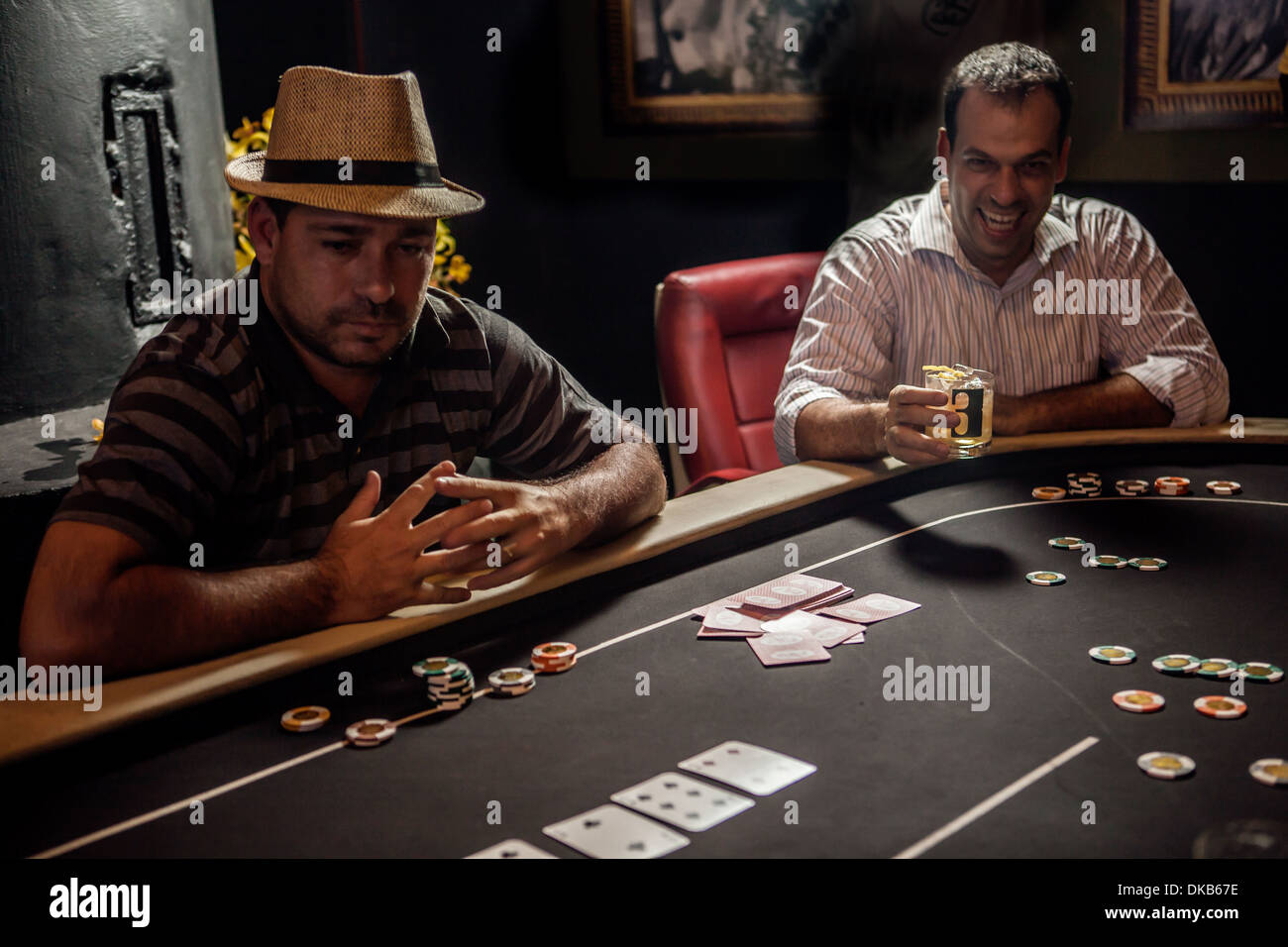 Metà uomini adulti giocando a poker e bere cocktail Foto Stock