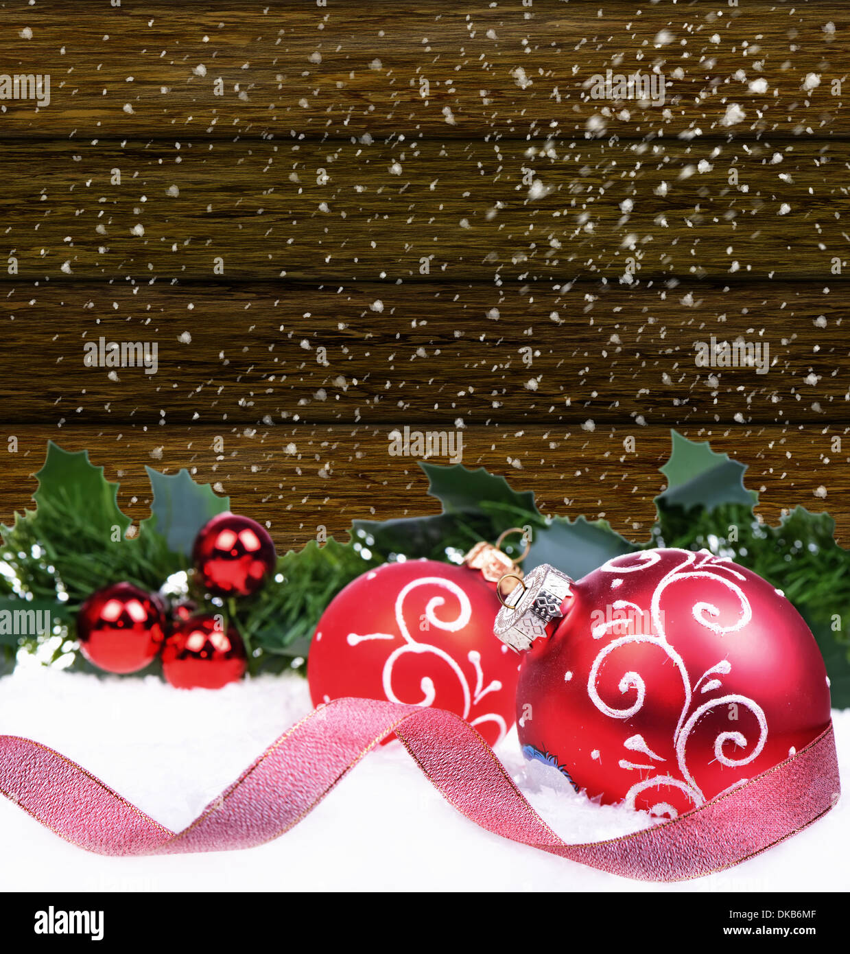 Sfondo di natale con palline rosse e holly foglie e bacche Foto Stock