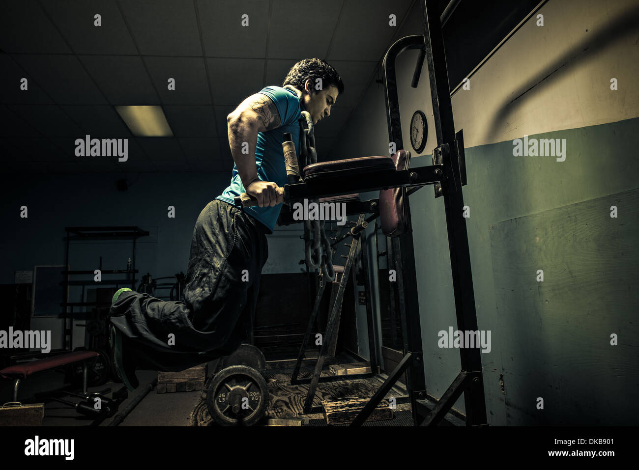 Weightlifter in dark palestra, pressa da banco Foto Stock