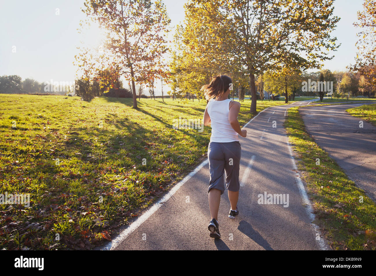 Donna in corsa nel parco, sfondo fitness Foto Stock
