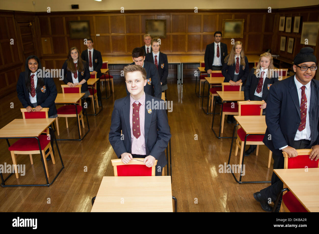 Gli scolari adolescenti in piedi nella classe di esame Foto Stock