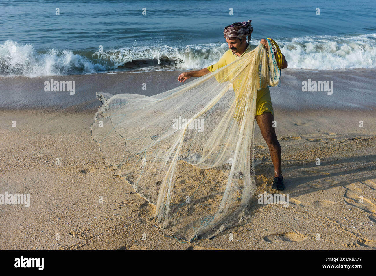 I pescatori con la mano la net si prepara a gettato in mare lungo la spiaggia Thottada nelle prime ore del mattino, 10 km a sud di Kannur, Kerala. Foto Stock