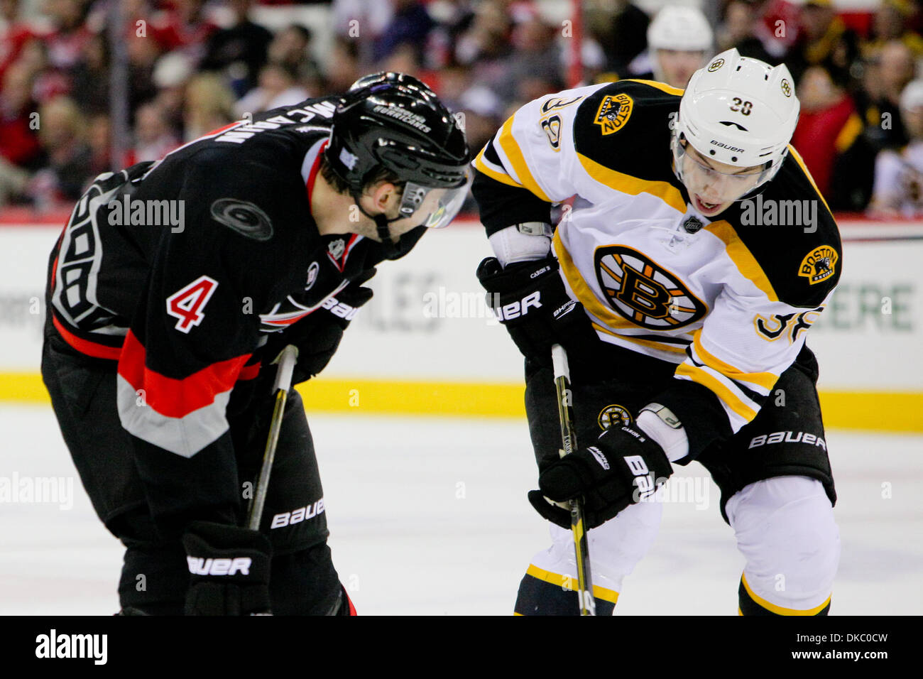 Ottobre 12, 2011 - Raleigh, North Carolina, Stati Uniti - Carolina Hurricanes defenceman Jamie McBain (4) e Boston Bruins ala sinistra della Giordania Caron (38) face off.uragani sconfitto i Bruins 3-2 a RBC Center in Raleigh North Carolina. (Credito Immagine: © Anthony Barham/Southcreek/ZUMAPRESS.com) Foto Stock