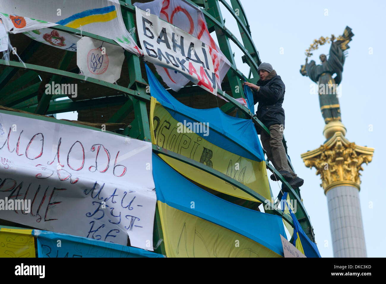 Kiev, Ucraina. 04 Dic, 2013. Il lavoro di cornice di un albero di Natale, coperto con striscioni di protesta da parte dei dimostranti, è photrographed presso la piazza Indipendenza (Piazza Maidan) a Kiev, Ucraina, 04 dicembre 2013. Poiché tredici giorni, migliaia di pro-Western dimostranti protestano contro il presidente ucraino Viktor Janukowitsch. Foto: TIM BRAKEMEIER/dpa/Alamy Live News Foto Stock