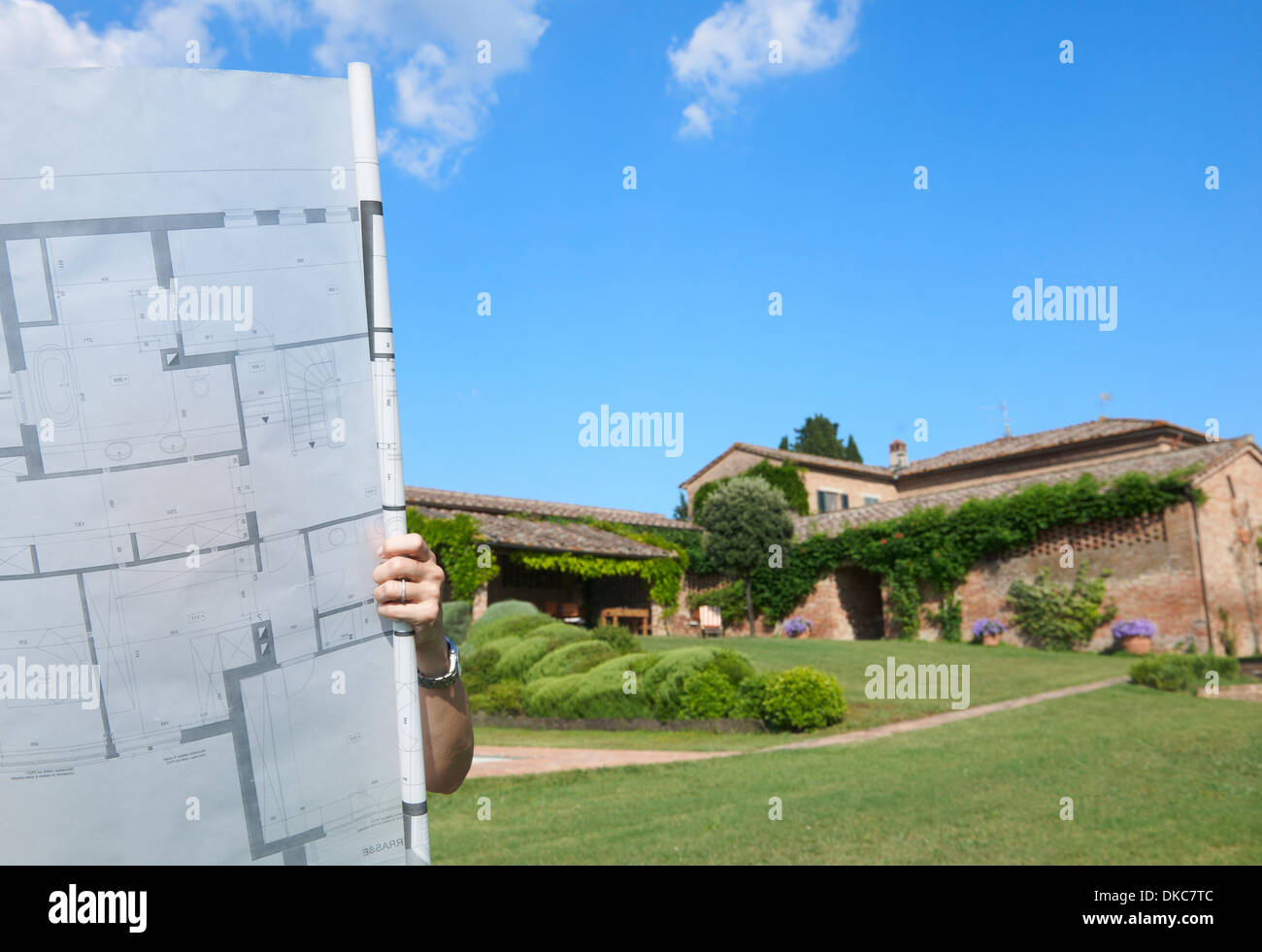 Donna in piedi fuori casa, coperto da architetti PIANI Foto Stock