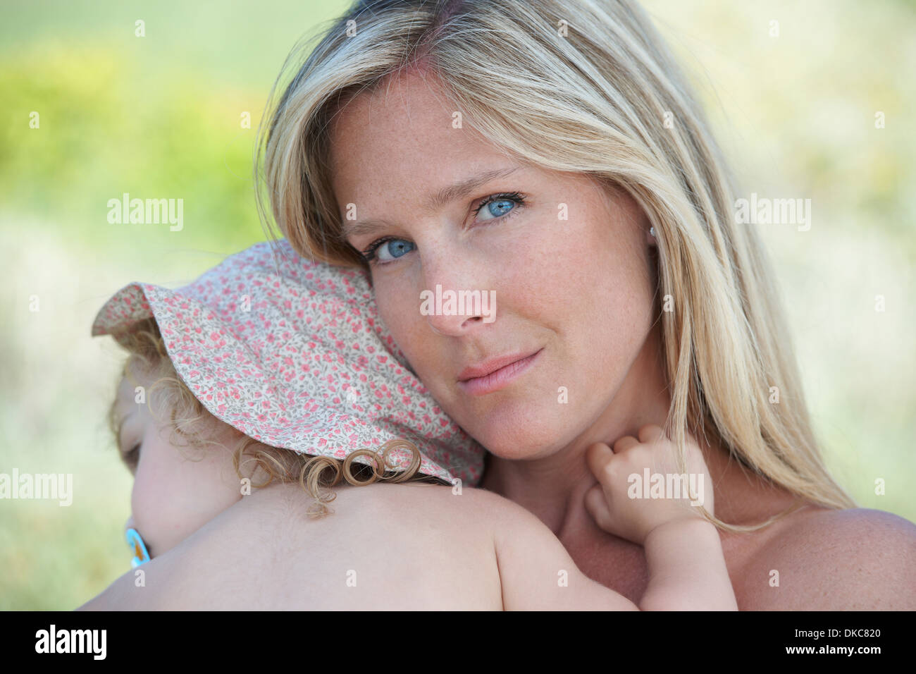 Madre abbracciando il toddler indossando cappello Foto Stock
