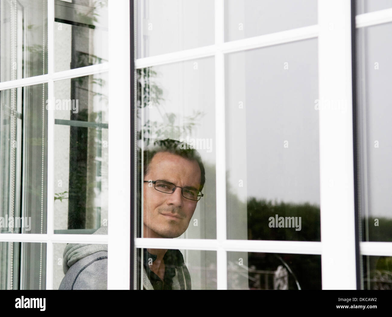 Ritratto di metà uomo adulto guardando fuori della finestra Foto Stock