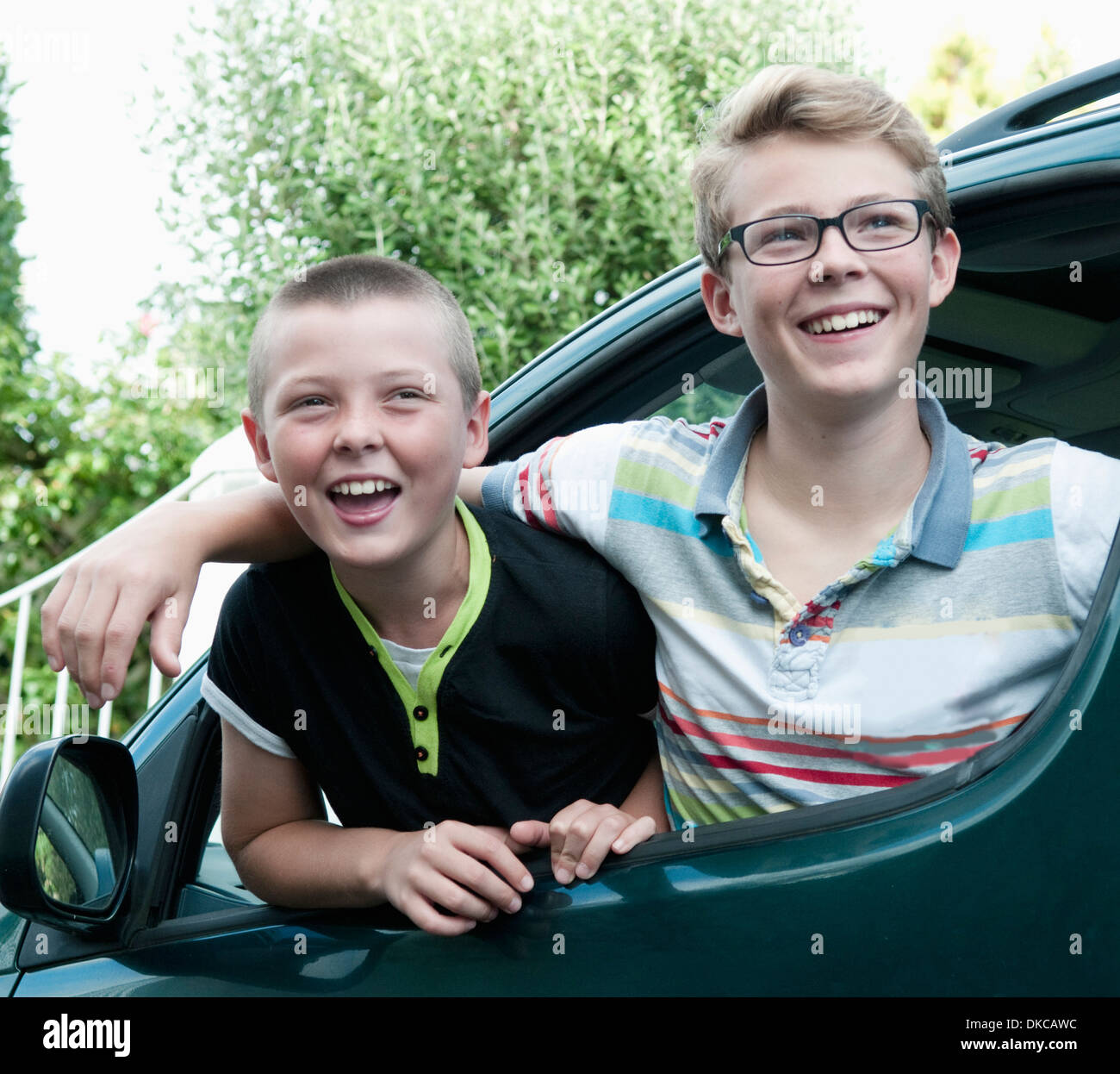 Ritratto di due fratelli proteso al di fuori della finestra di auto Foto Stock