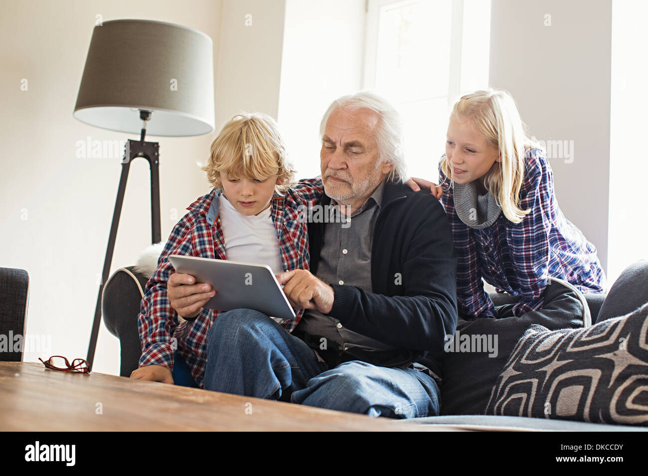 Nonno utilizzando tavoletta digitale con i nipoti Foto Stock