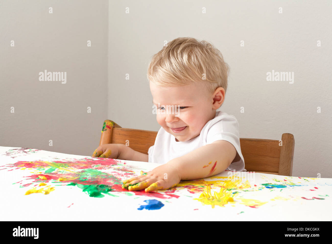 Little Boy giocando con il dito le vernici Foto Stock