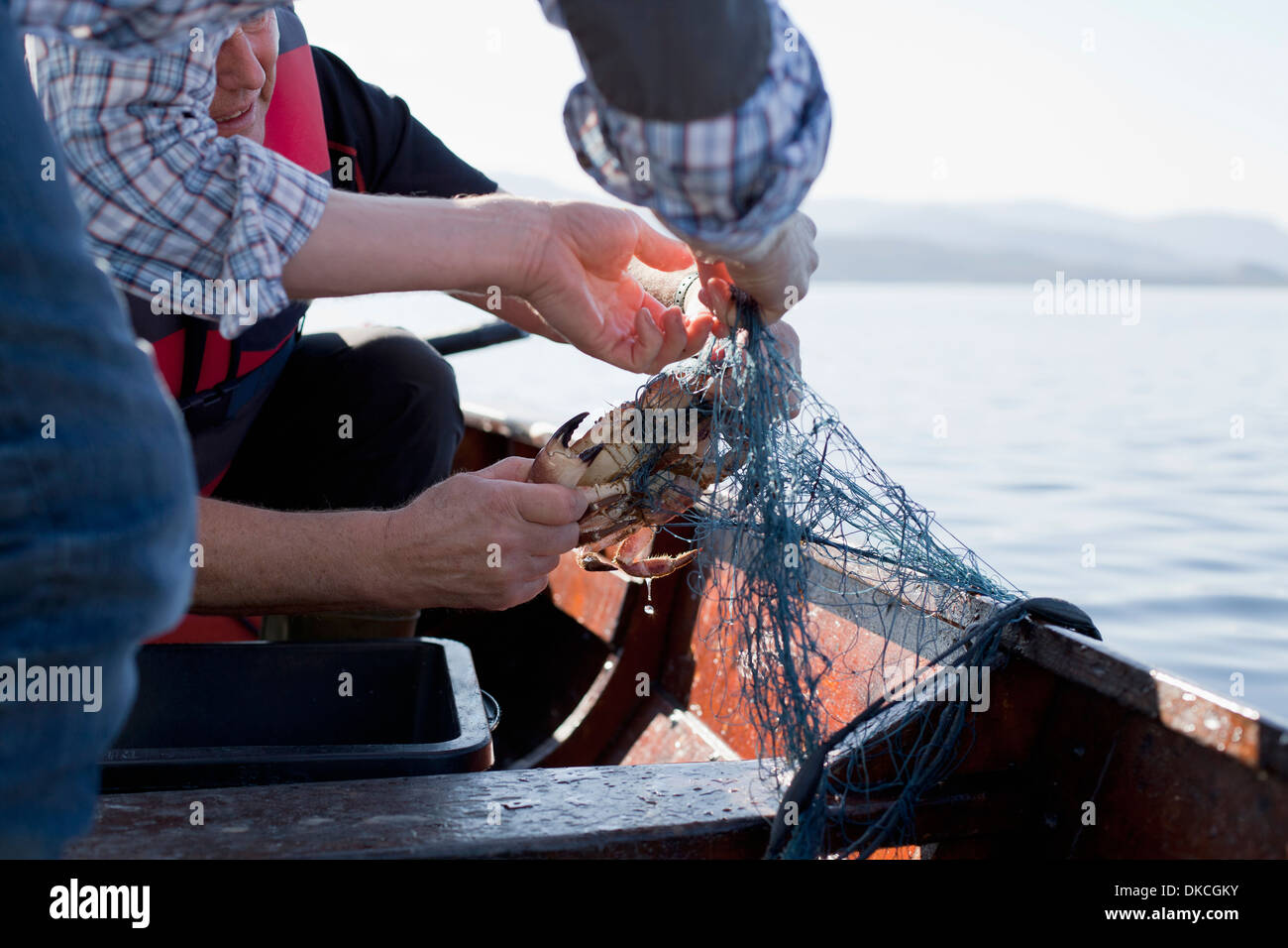 Le persone sulla barca da pesca dei granchi, Aure, Norvegia Foto Stock