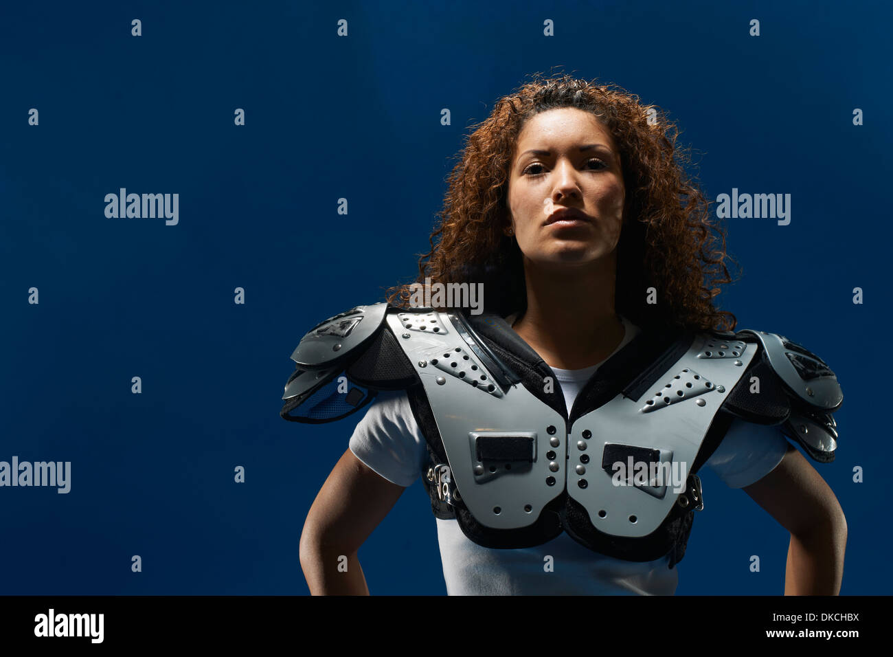 Ritratto di femmina calciatore americano usura pastiglie di spallamento Foto Stock