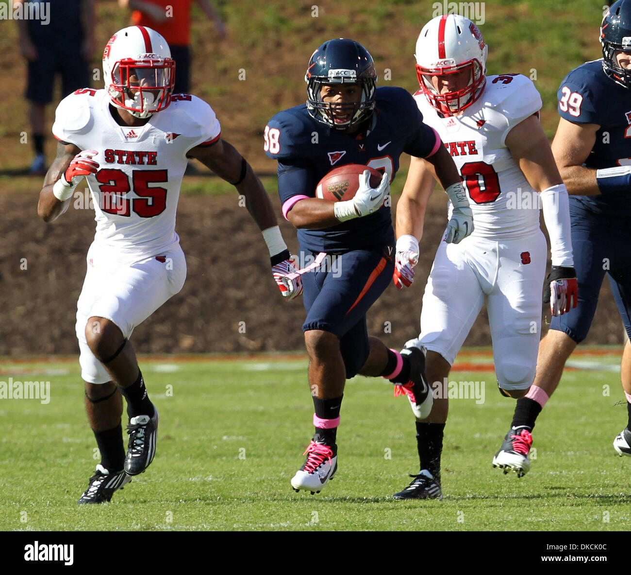 Ottobre 22, 2011 - Charlottesville, Virginia, Stati Uniti - Virginia Cavaliers running back KHALEK pastore (38) corre passato dello stato del Nord Carolina sicurezza Wolfpack DONTAE JOHNSON (25) e la North Carolina State Wolfpack Brandan sicurezza Vescovo (30) durante un NCAA Football gioco allo stadio di Scott. NC stato sconfitto Virginia 28-14. (Credito Immagine: © Andrew Shurtleff/ZUMAPRESS.com) Foto Stock