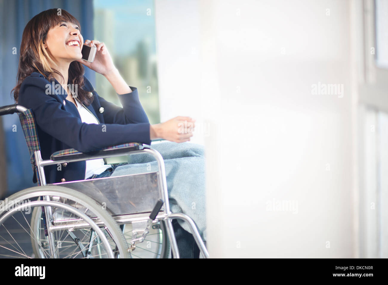 Donna in carrozzina tramite telefono cellulare Foto Stock
