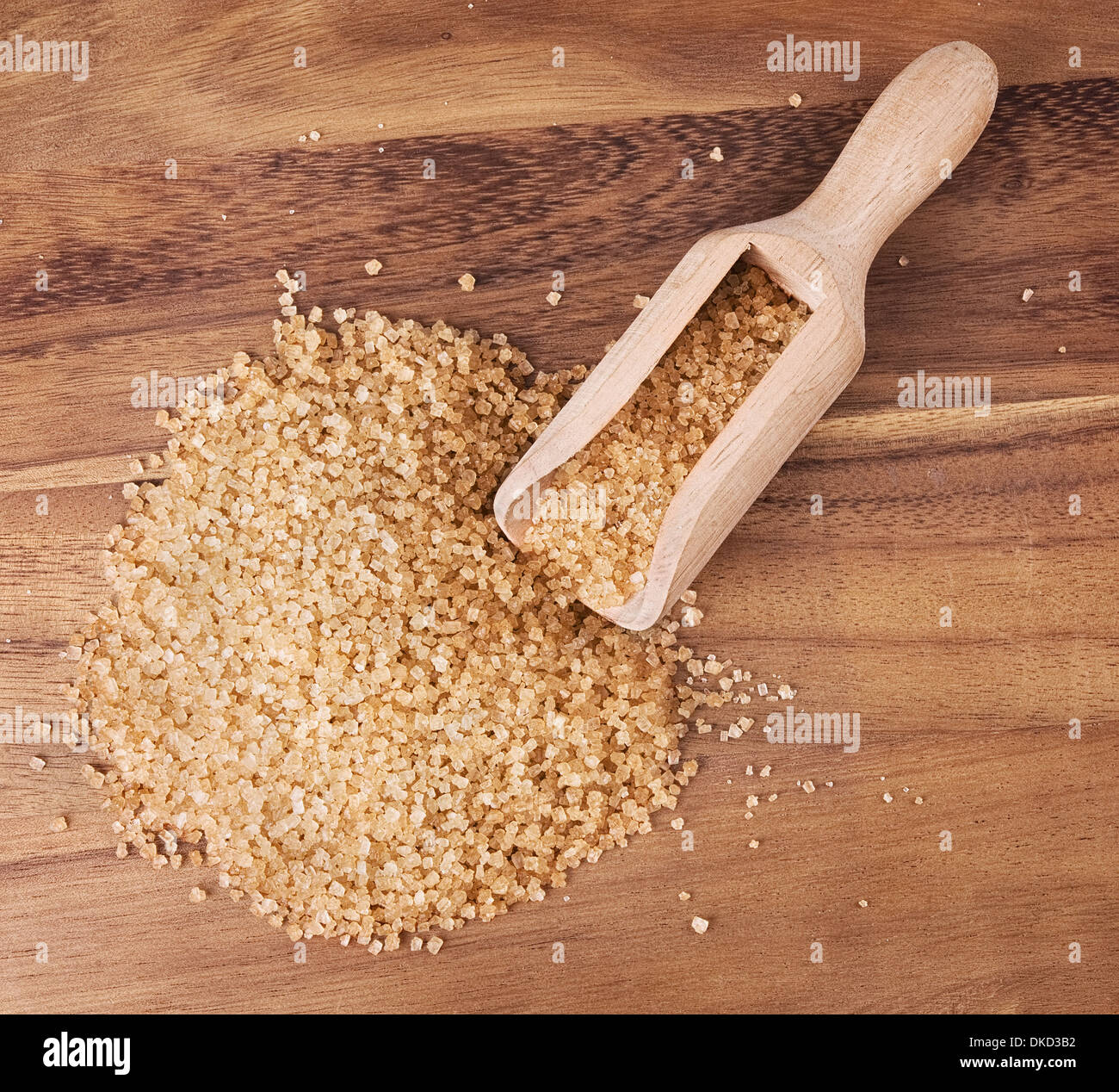 Lo zucchero di canna con il cucchiaio di legno su sfondo di legno Foto Stock