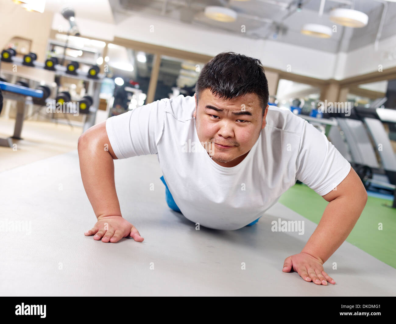 Uomo sovrappeso esercizio in palestra Foto Stock