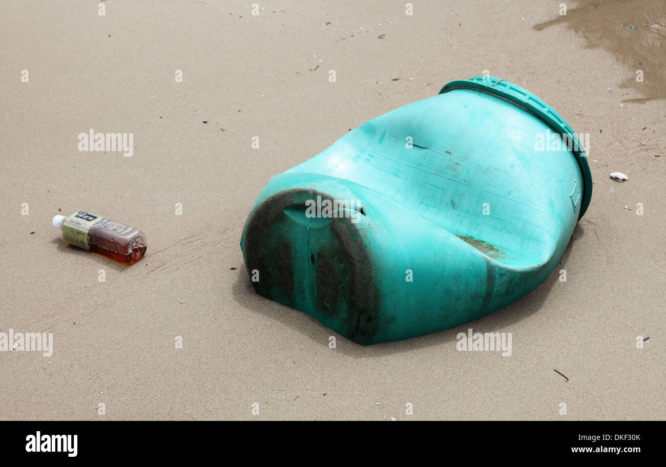 Si tratta di una foto di un verde canna di plastica che è sulla sabbia sulla spiaggia vicino al mare o oceano. Ovviamente si tratta di inquinamento Foto Stock