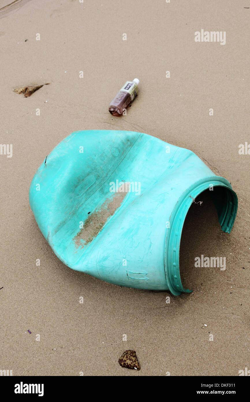 Si tratta di una foto di un verde canna di plastica che è sulla sabbia sulla spiaggia vicino al mare o oceano. Ovviamente si tratta di inquinamento Foto Stock