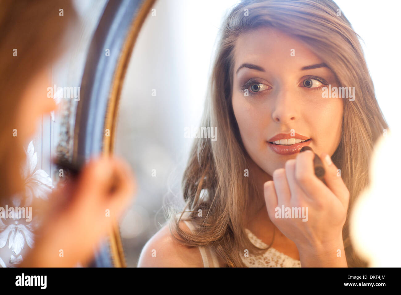 Giovane donna rossetto in specchio Foto Stock