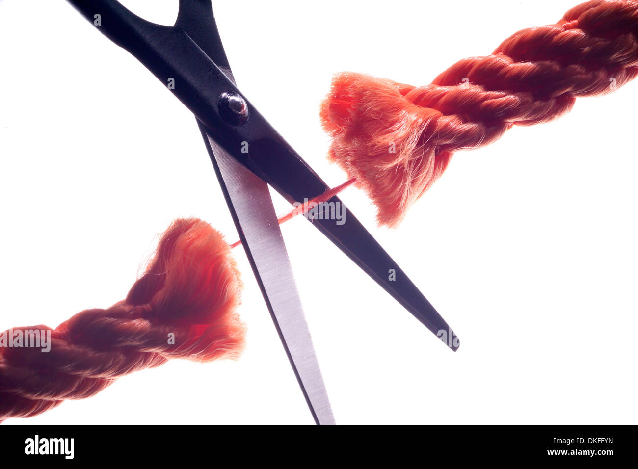 Il taglio a forbice l'ultimo thread rimanenti di una fune Foto Stock
