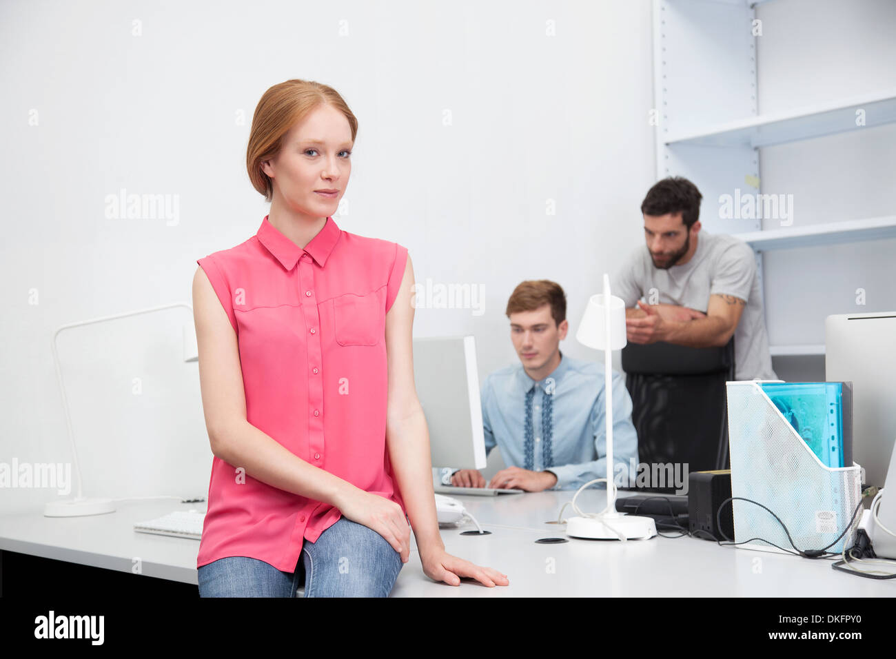 Giovane donna indossa camicetta rosa in ufficio Foto Stock