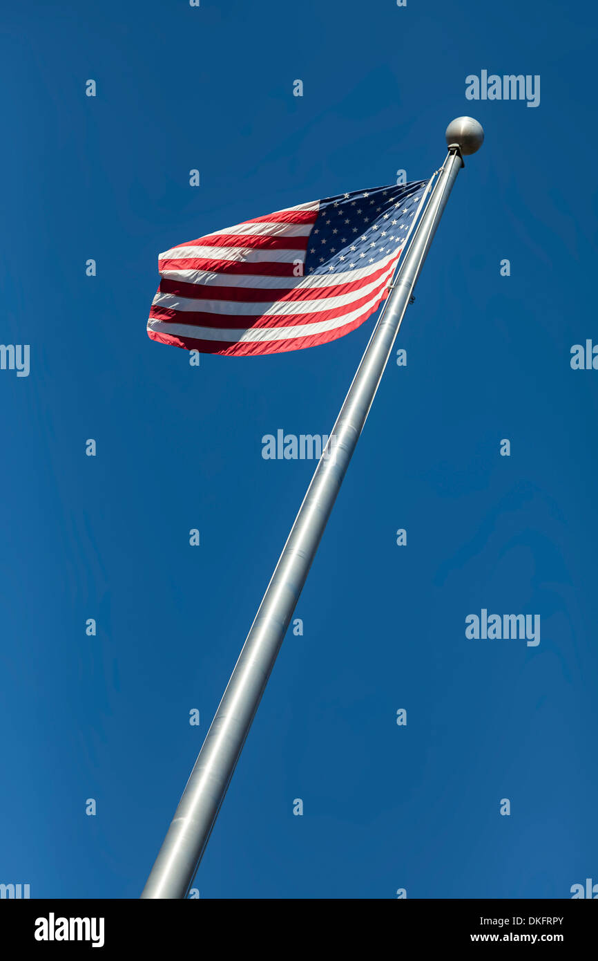 Bandiera americana conosciuta anche come vecchia gloria o a stelle e strisce onde sulla cima di un palo di bandiera contro un cielo blu. Stati Uniti d'America Foto Stock