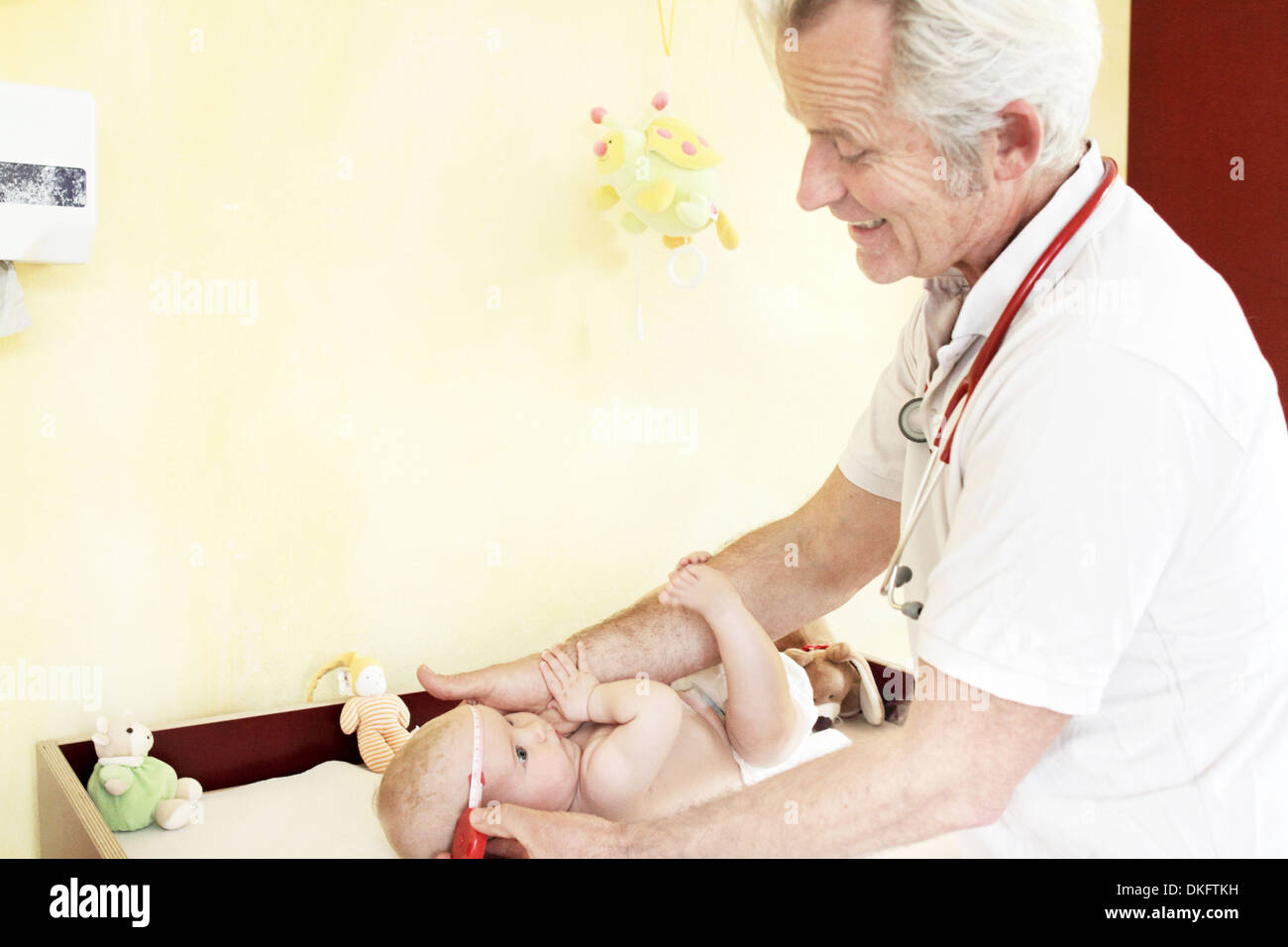 Pediatra esaminando Baby girl, testa di misurazione Foto Stock