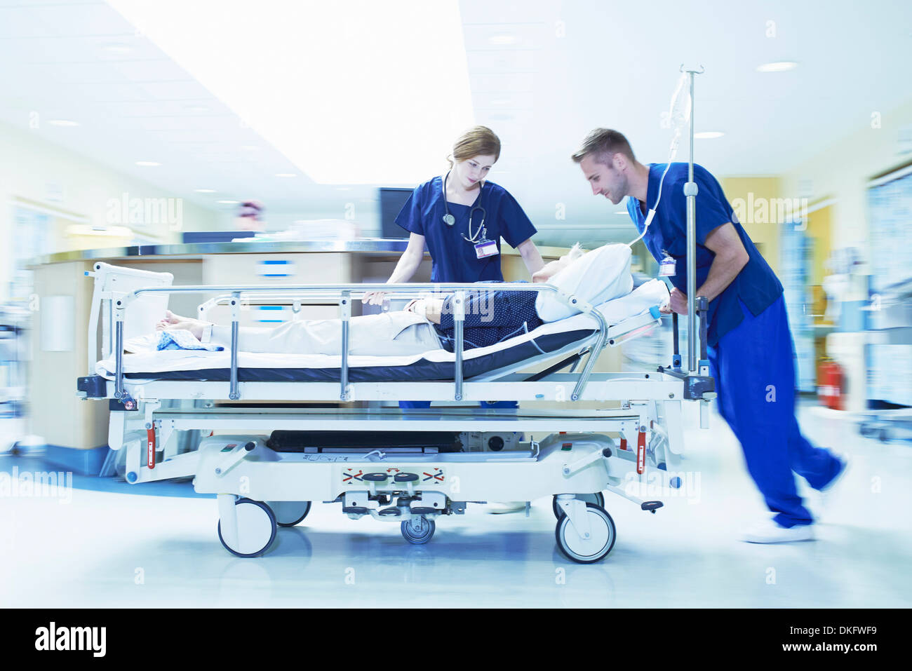 Due medici spingendo gurney in pronto soccorso dell'ospedale Foto Stock