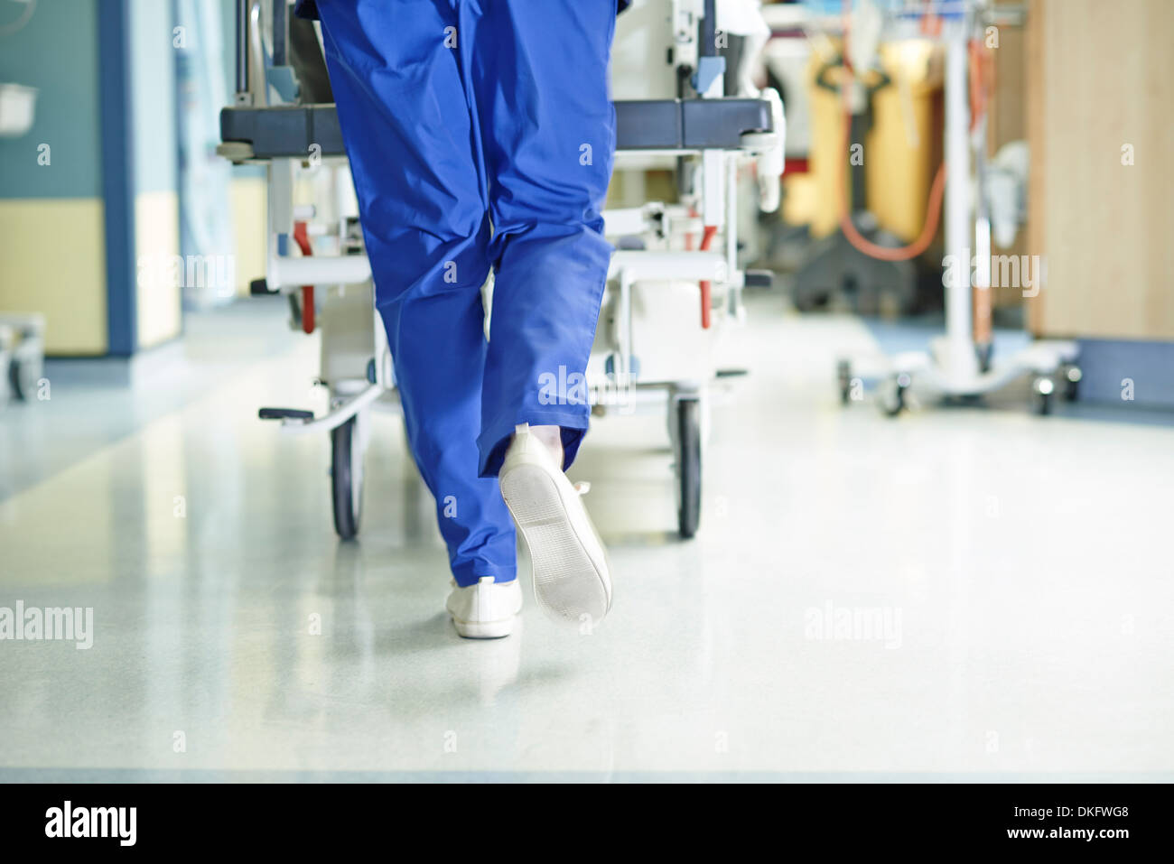 Gambe di medic in esecuzione con barella lungo il corridoio di ospedale Foto Stock
