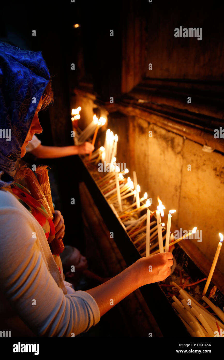 Pellegrini accendendo candele nel Santo Sepolcro Chiesa di Gerusalemme, Israele, Medio Oriente Foto Stock