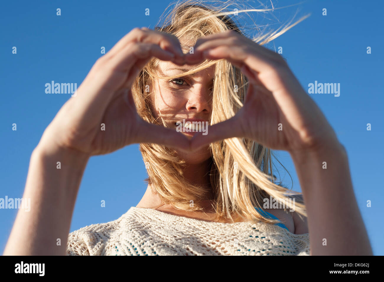 Ritratto di giovane donna facendo segno di cuore, Breezy Point, Queens, a New York, Stati Uniti d'America Foto Stock