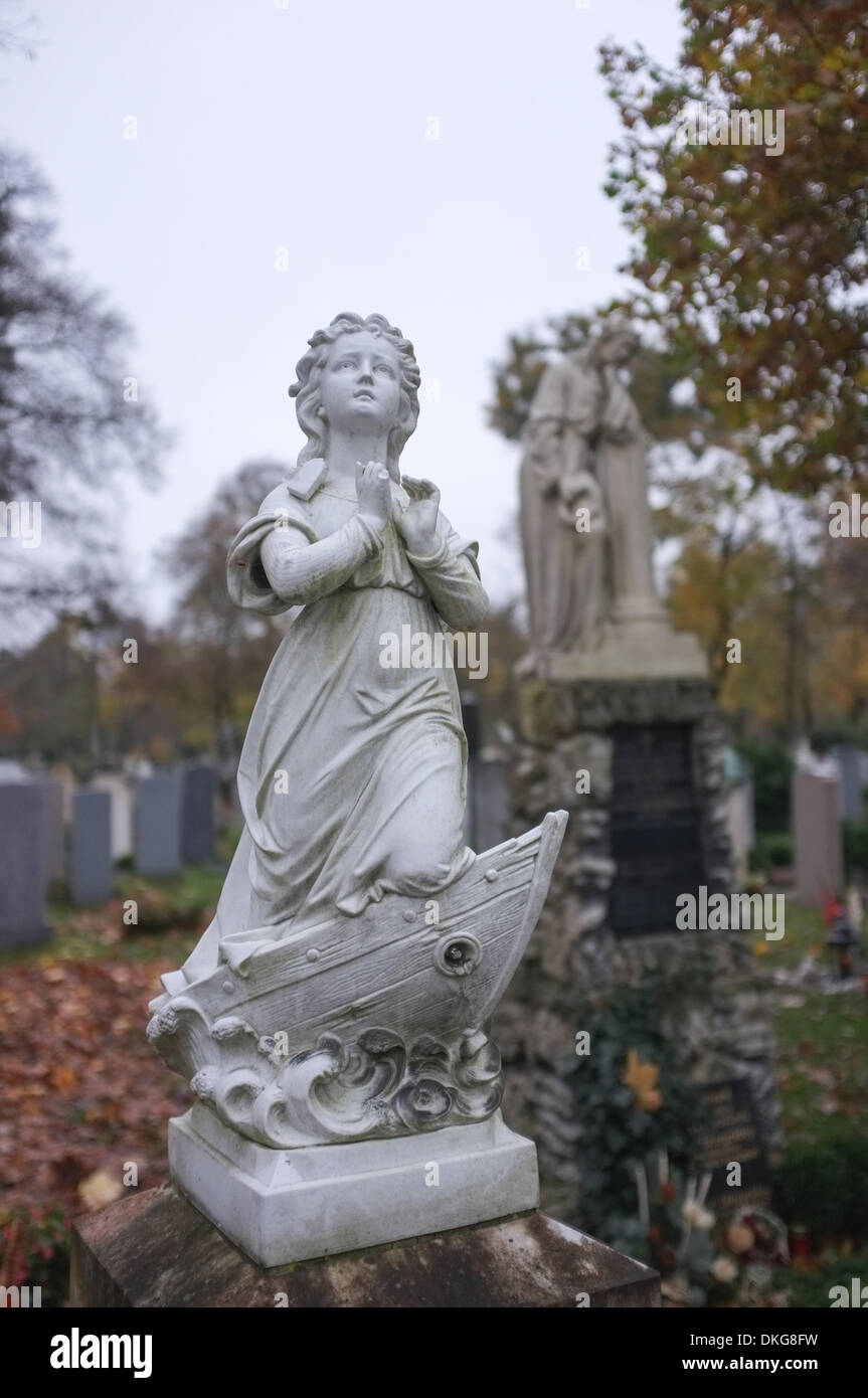 Cimitero a ovest di Monaco di Baviera - Novembre 2013 - Angelo statua pregando su una barca Foto Stock