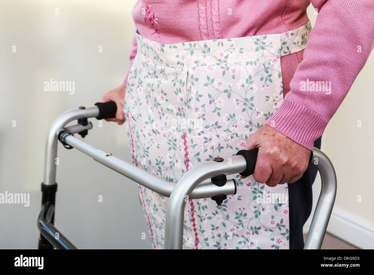 Anziana donna senior si alzò in piedi utilizzando un zimmer telaio per il sostegno permanente. Inghilterra, Regno Unito, Gran Bretagna Foto Stock