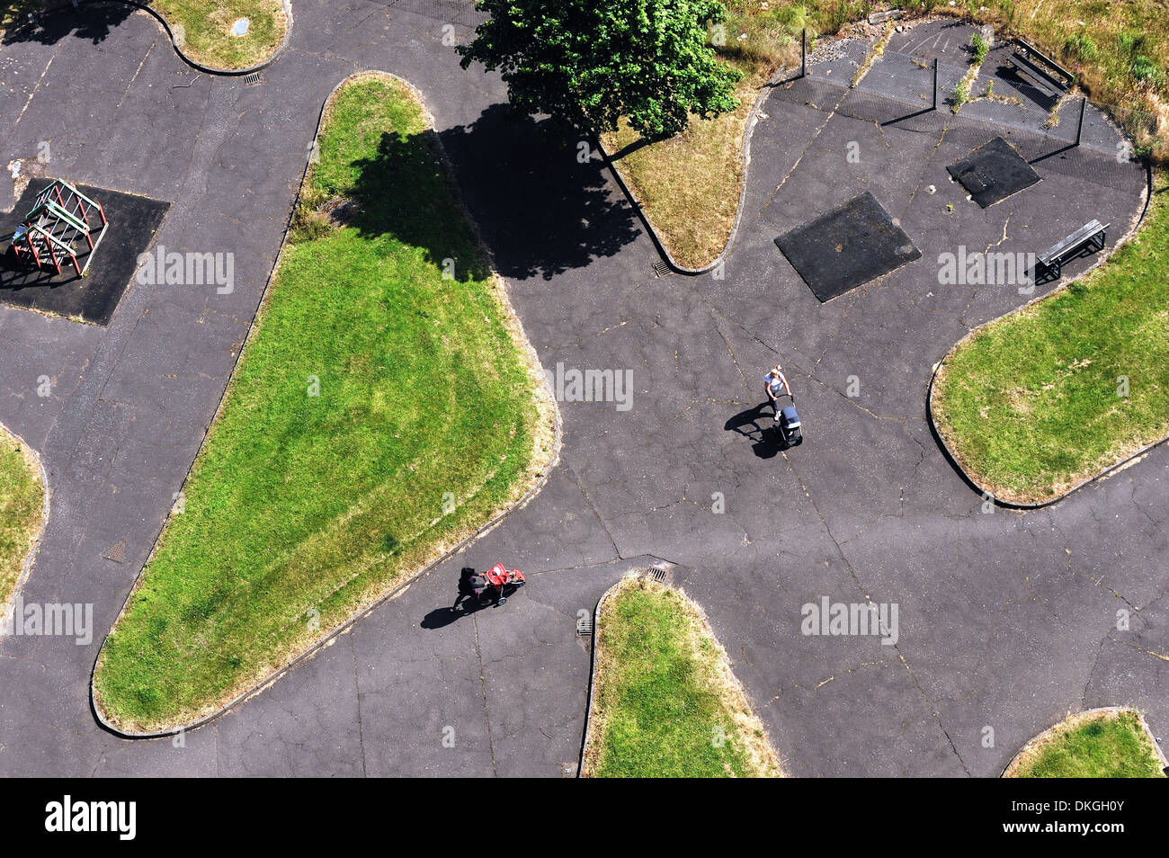 Guardando verso il basso sulla Gorbals, Glasgow, come due donne spingere carrozzine attraverso un parco giochi a Norfolk corte Foto Stock