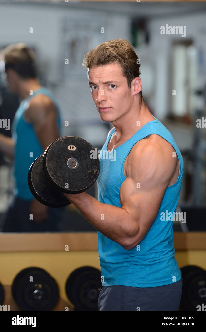 Giovane uomo che esercitano nel centro fitness Foto Stock