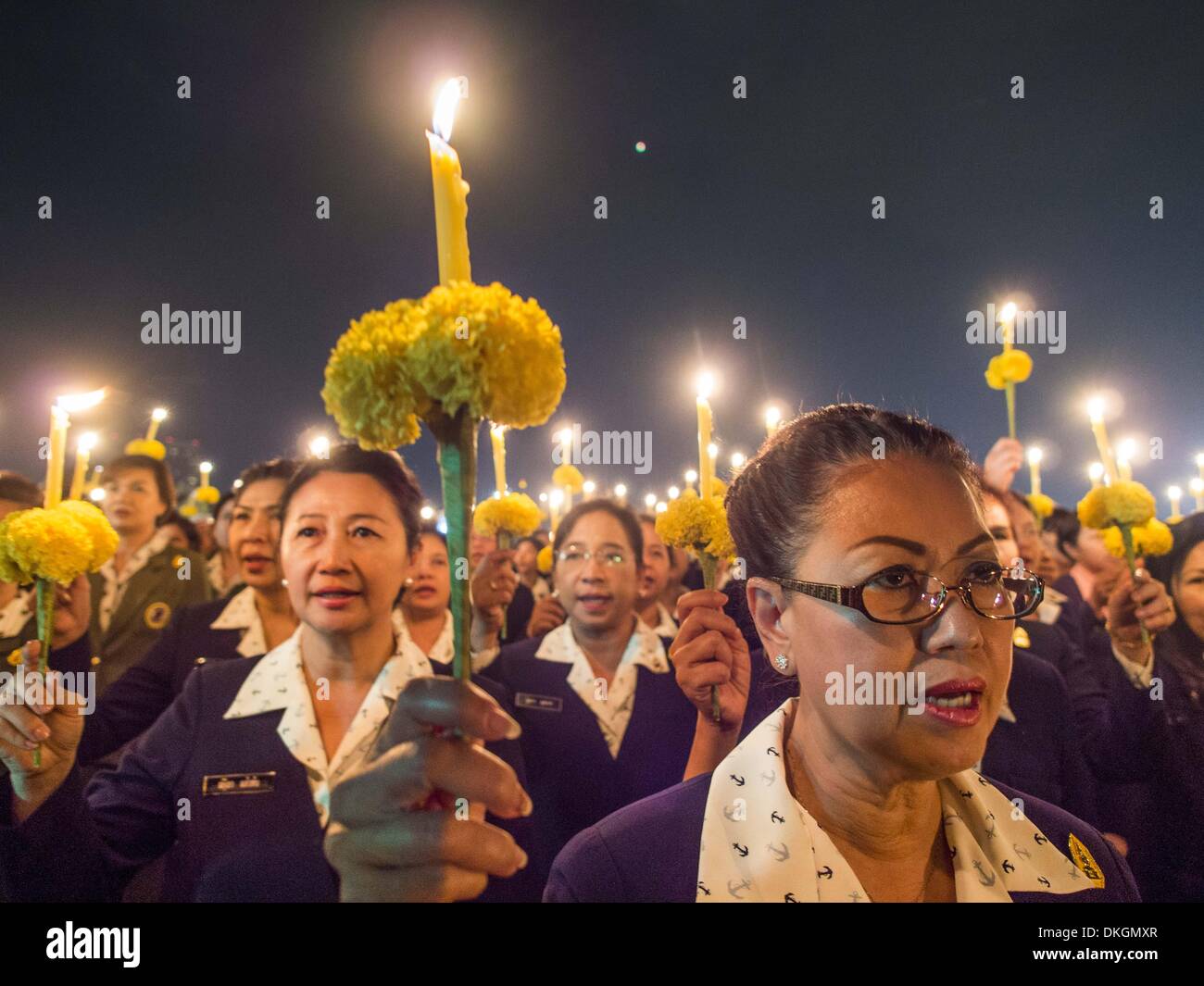 Bangkok, Tailandia. 5 Dic, 2013. Thai funzionari Tenere candele durante un servizio a lume di candela per il re. Thais osservato il 86º compleanno del loro venerato Re, B. Adulyadej. Servizi a lume di candela sono state tenute in tutto il paese. La protesta politica che hanno afferrato Bangkok sono stati in attesa per il giorno. © Jack Kurtz/ZUMAPRESS.com/Alamy Live News Foto Stock