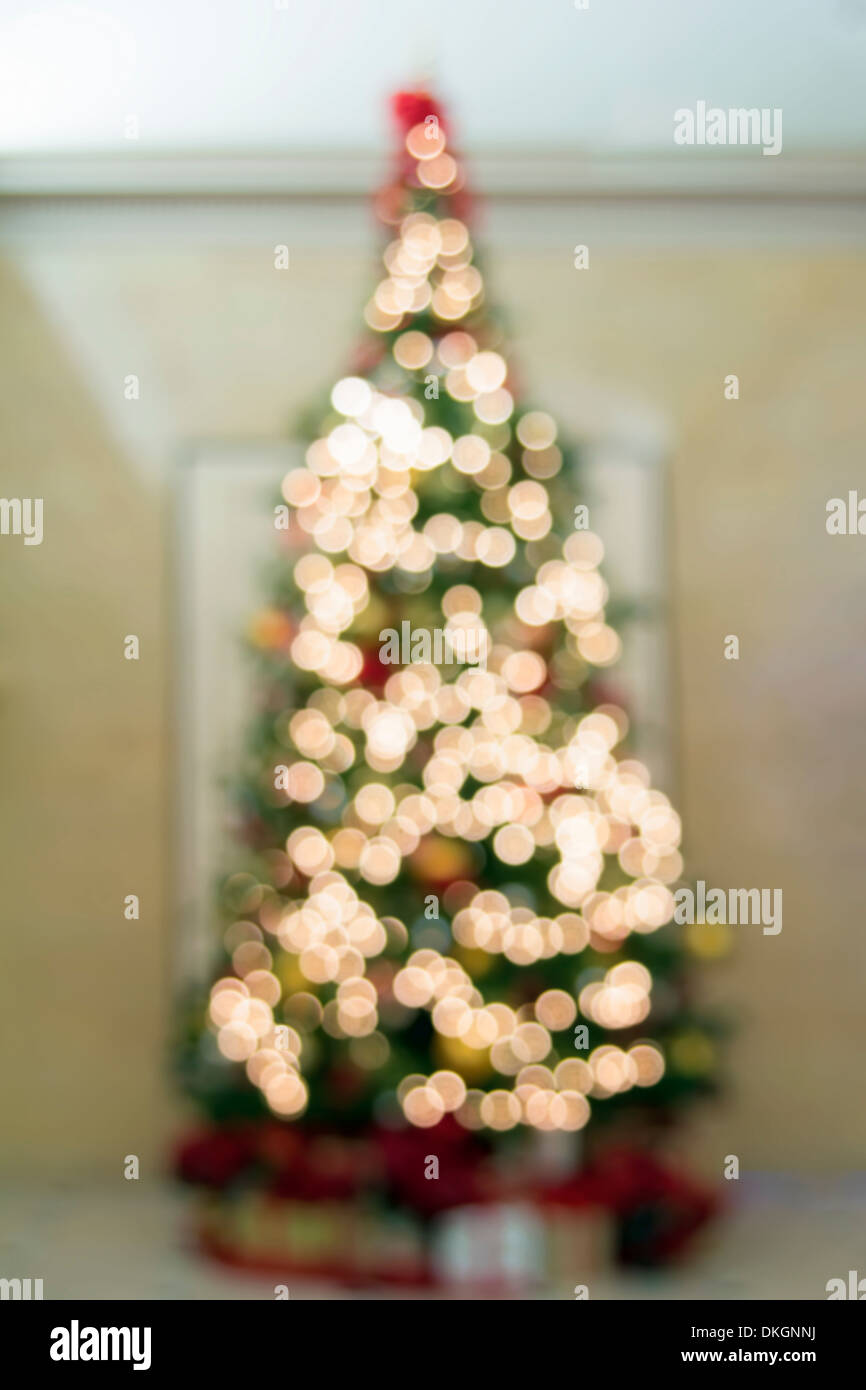 Albero di natale decorazione sfocati ornamenti nastri Poinsettia e presenta sotto l'albero con luci Bokeh di fondo Foto Stock