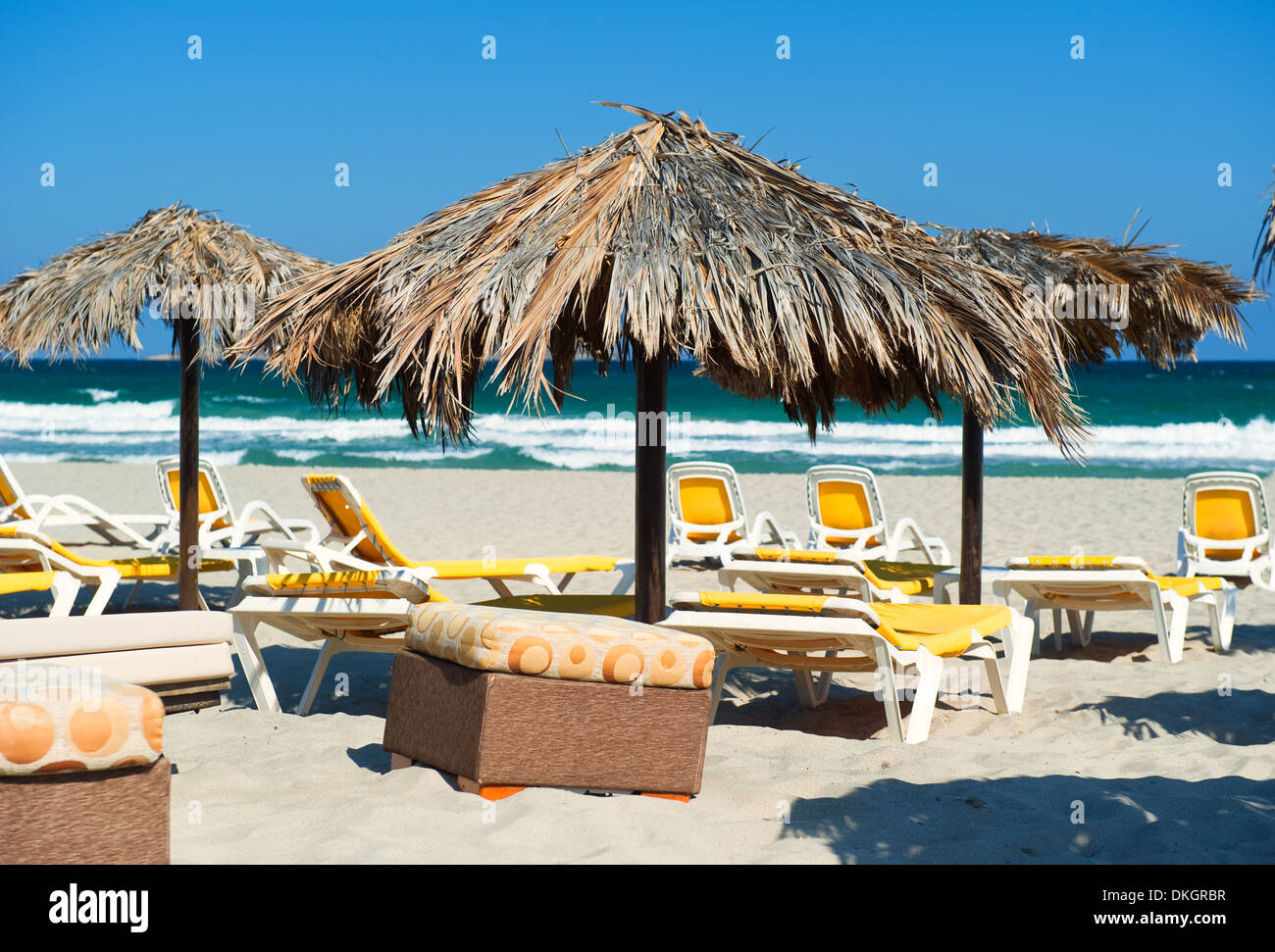 Ombrelloni con sedie a sdraio sulla spiaggia Foto Stock
