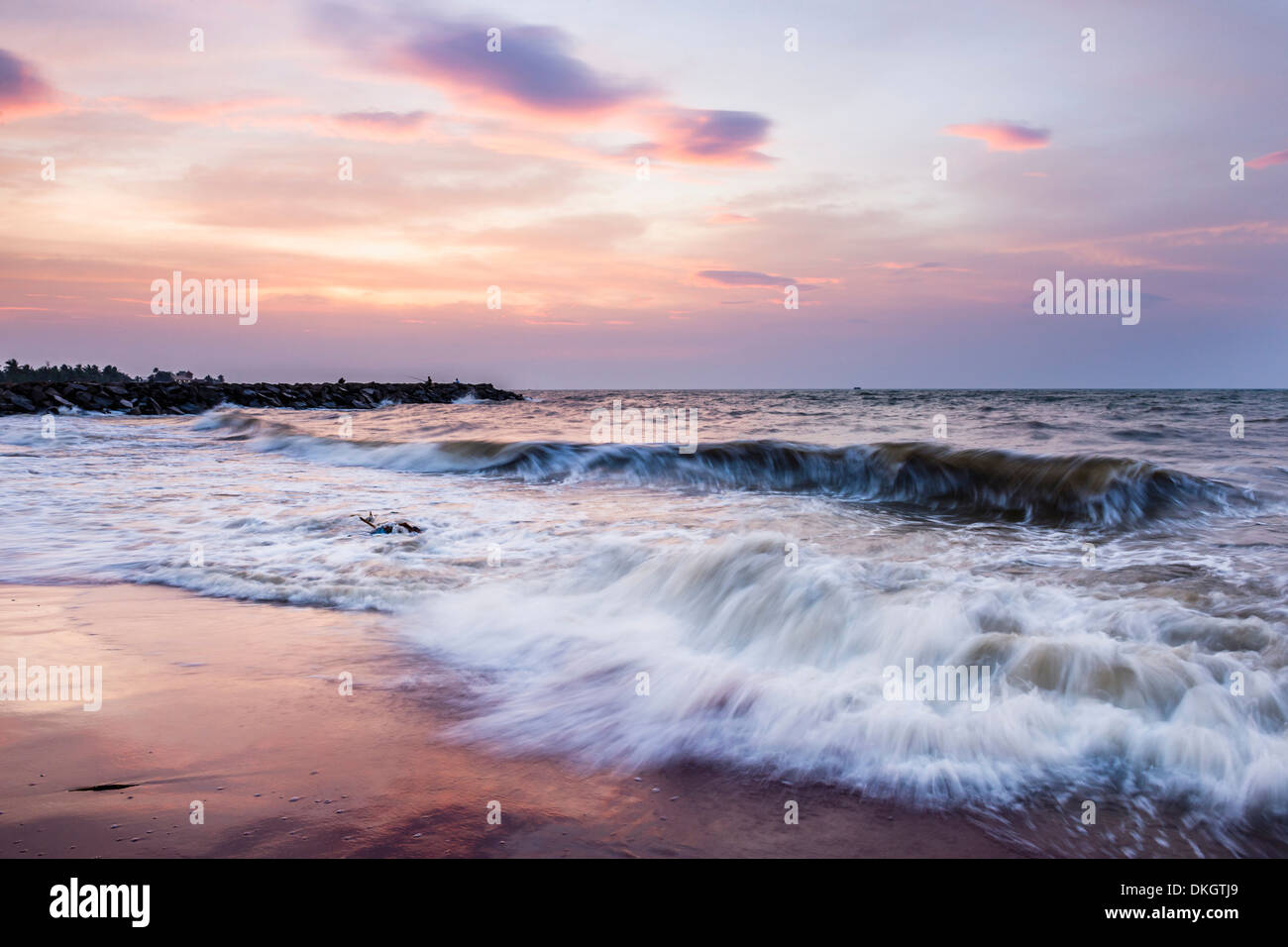 Onde che si infrangono sulla spiaggia di Negombo al tramonto, sulla costa occidentale dello Sri Lanka, in Asia Foto Stock