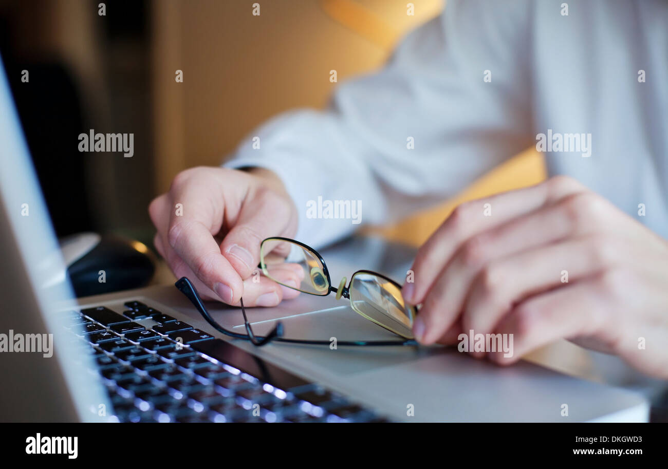 Le mani dell uomo d affari con gli occhiali sulla tastiera del notebook Foto Stock