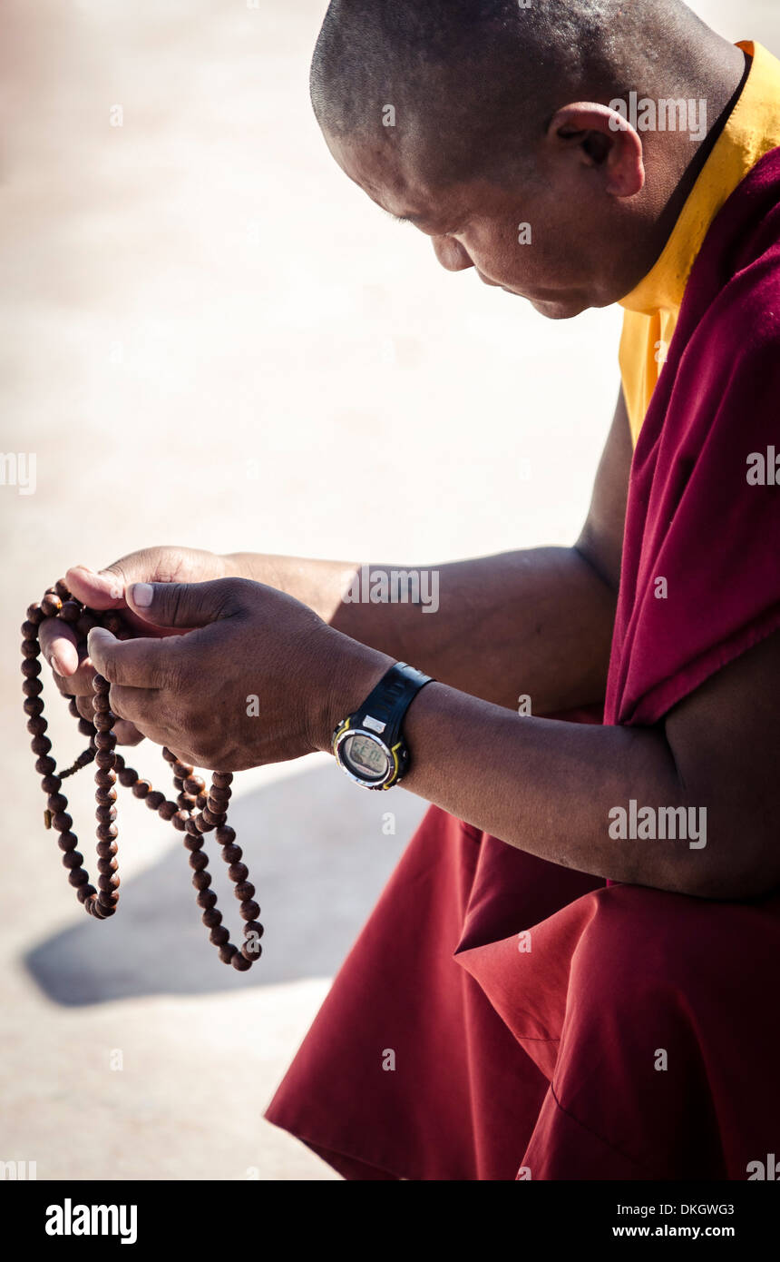 Un monaco buddista prega tramite una serie di grani di preghiera (Japa Mala), Bodhnath stupa, Bodhnath, Nepal, Asia Foto Stock